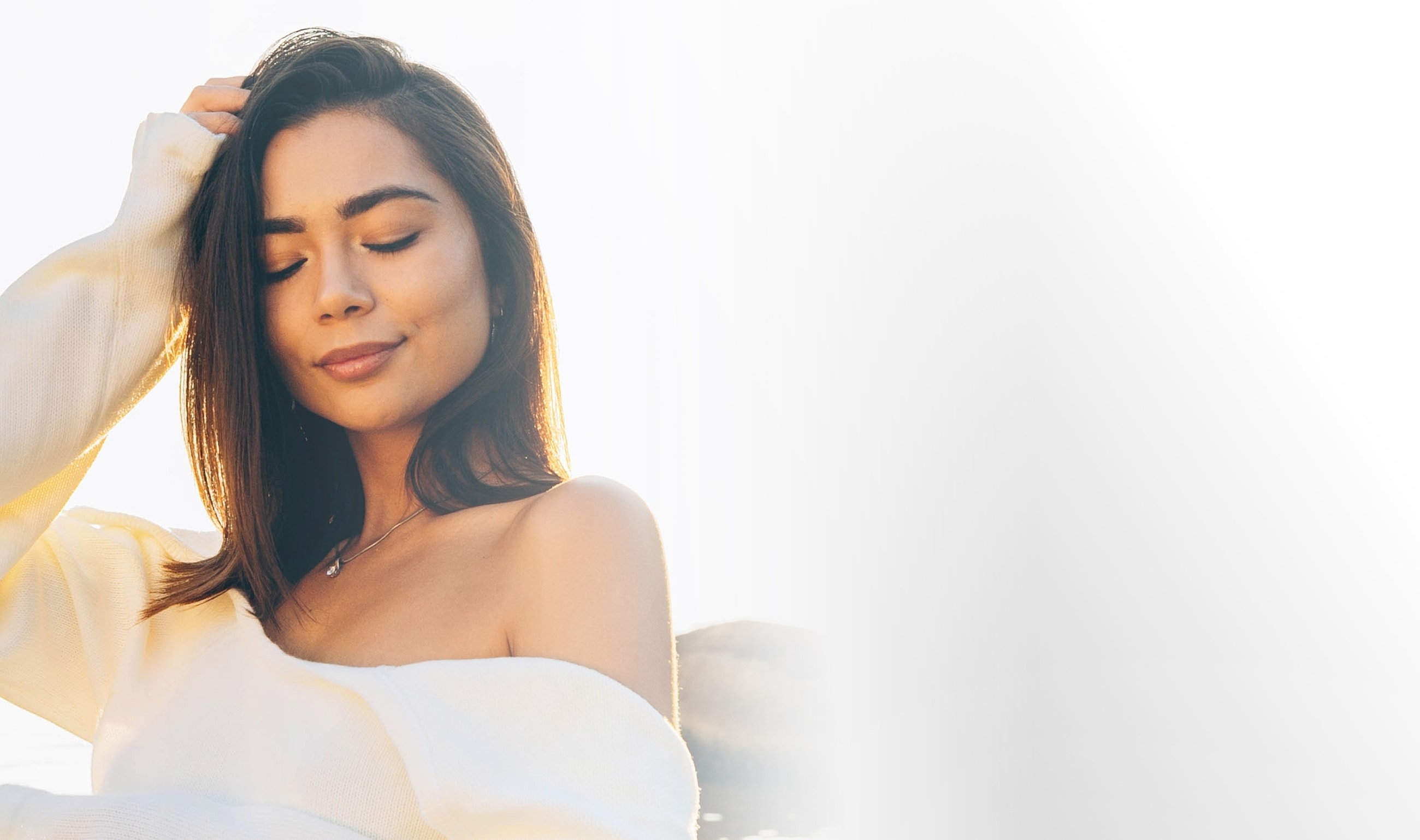 Woman with closed eyes in soft sunlight.
