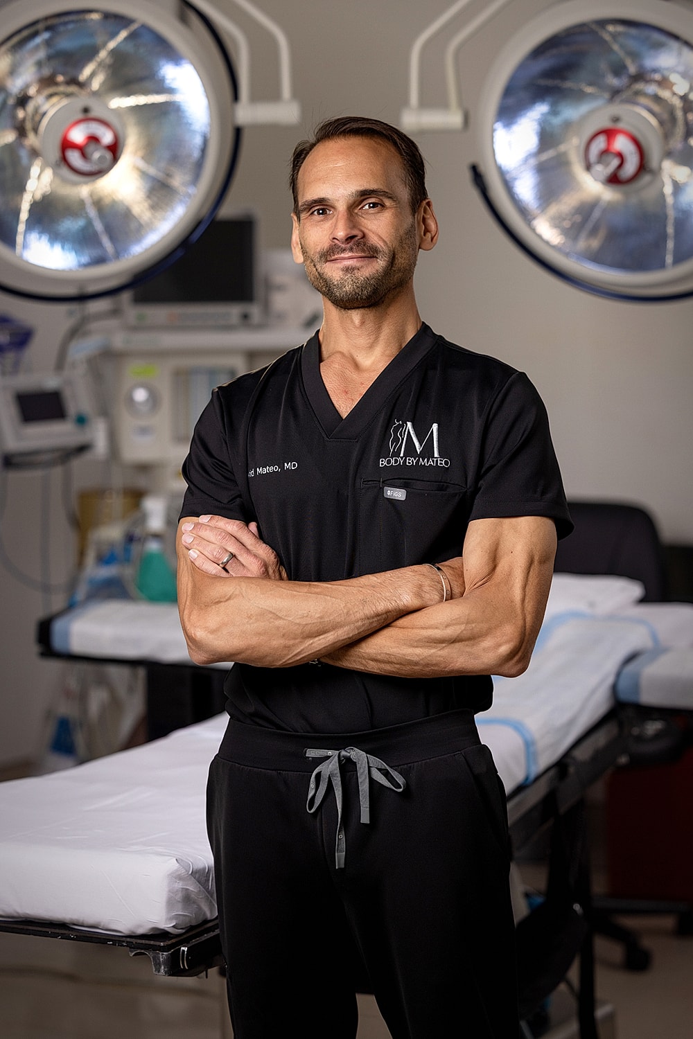 Surgeon in operating room with arms crossed.