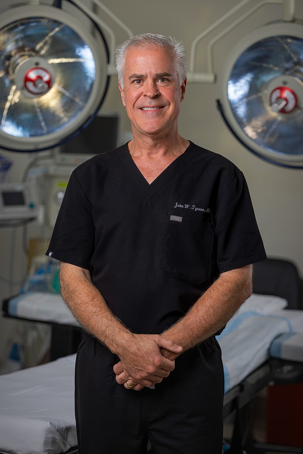 Surgeon in operating room with medical equipment.
