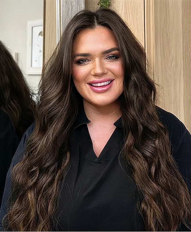 Smiling woman with long, wavy hair.
