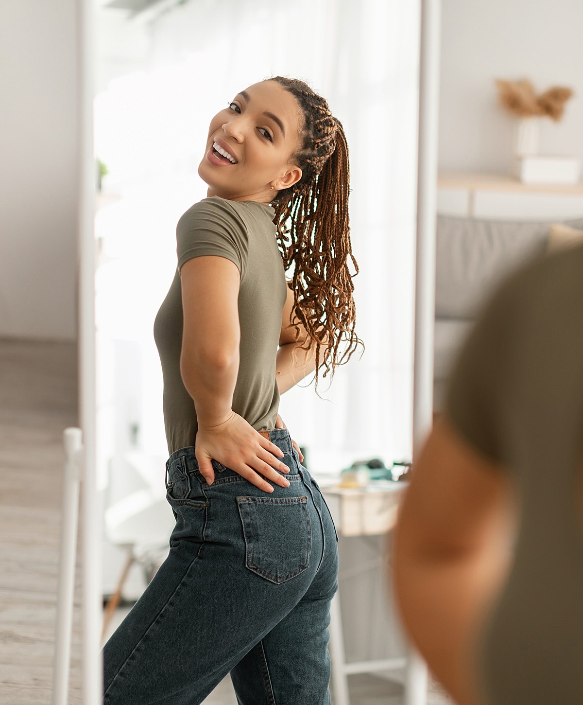 Gainesville, FL weight loss model poses in front of mirror.
