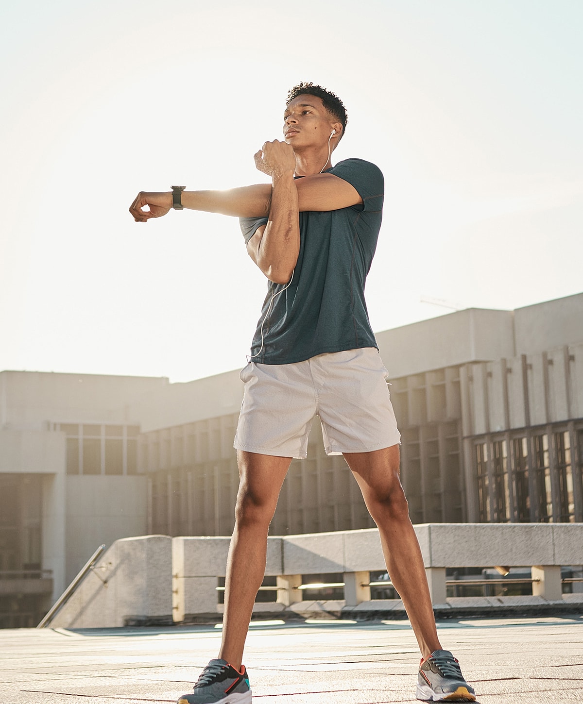Man stretching outdoors in athletic wear.