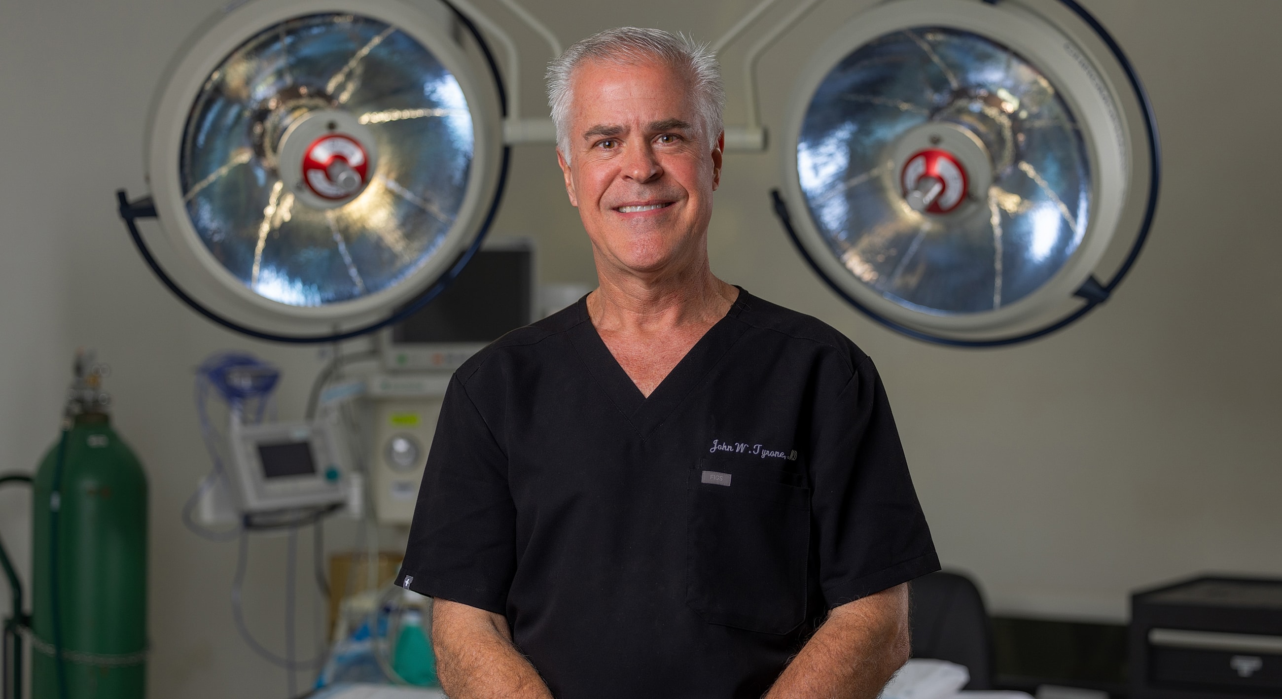 Surgeon smiling in an operating room setting.