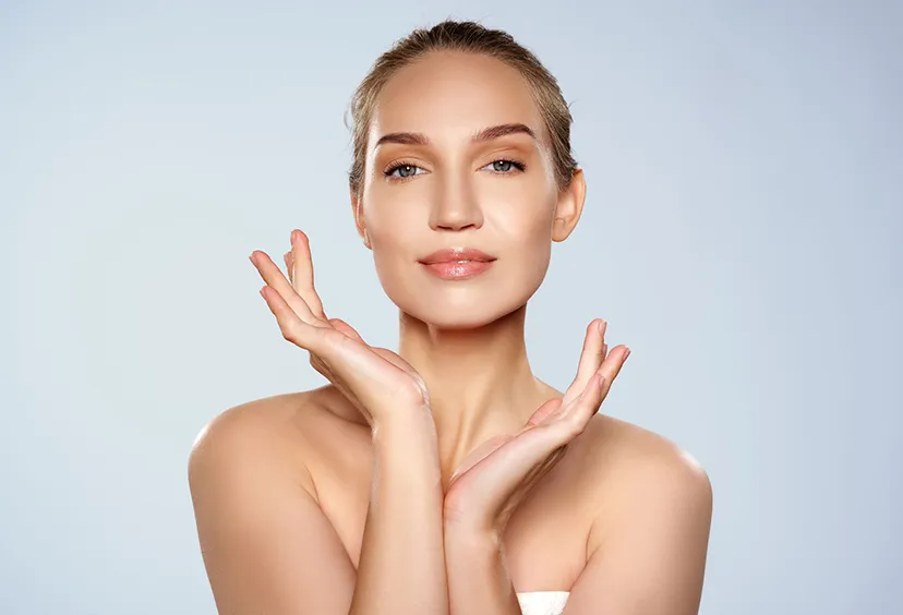 Woman in a tube top framing her face with her hands